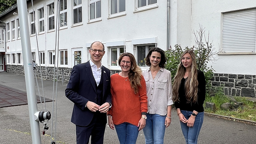 Vier Leute stehen unter einem Sonnensegel.