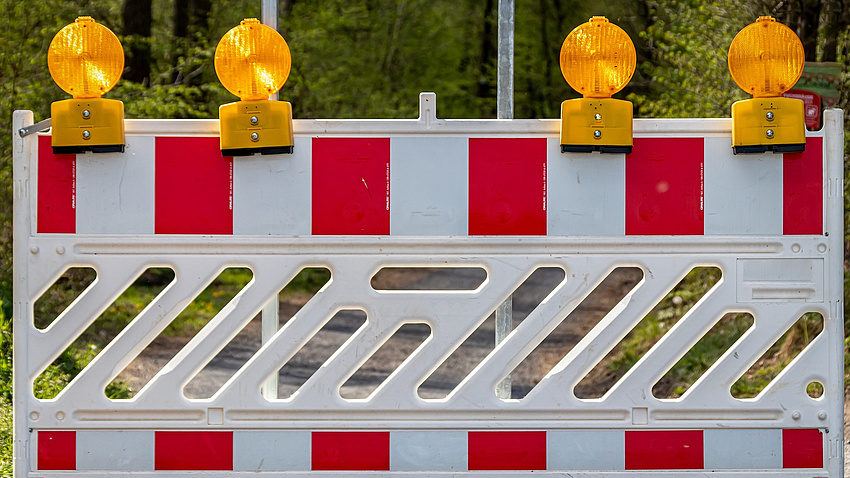Eine rot-weiße Baustellenbarke.
