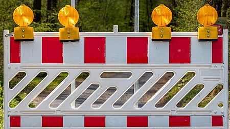 Eine rot-weiße Baustellenbarke.