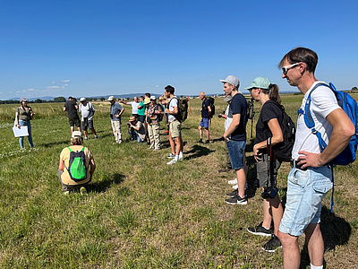 Die Teilnehmer/innen des Naturspaziergangs erfahren hier etwas über die verschiedenen Grünlandtypen im Mähried bei Staden.