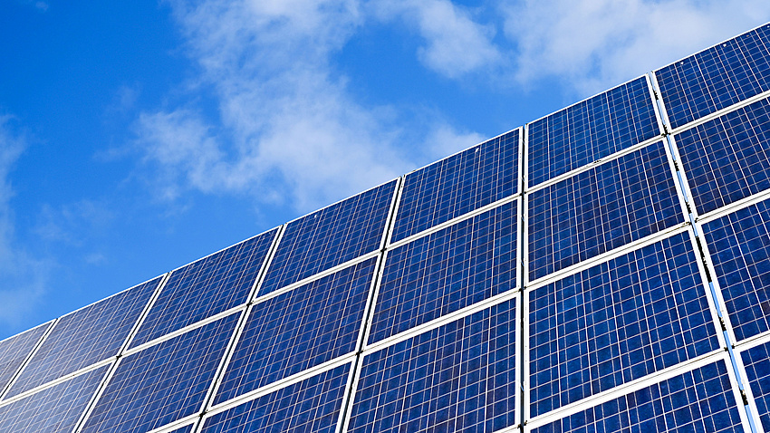 Photovoltaik-Photovoltaikmodule vor blauem, leicht bewölktem Himmel