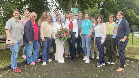 Eine Gruppe von Menschen lächelt in die Kamera.