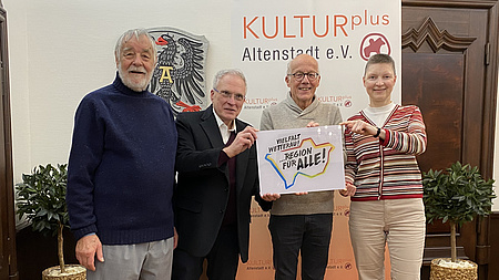 Kreisbeigeordnete Marion Götz übergibt ein Schild mit der Aufschrift "Vielfalt für alle" an Hans E. Seum und weitere Mitglieder des Vorstands.