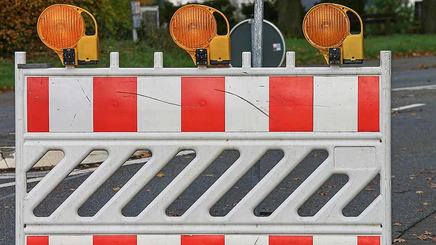 Eine rot-weiße Baustellenbarke.