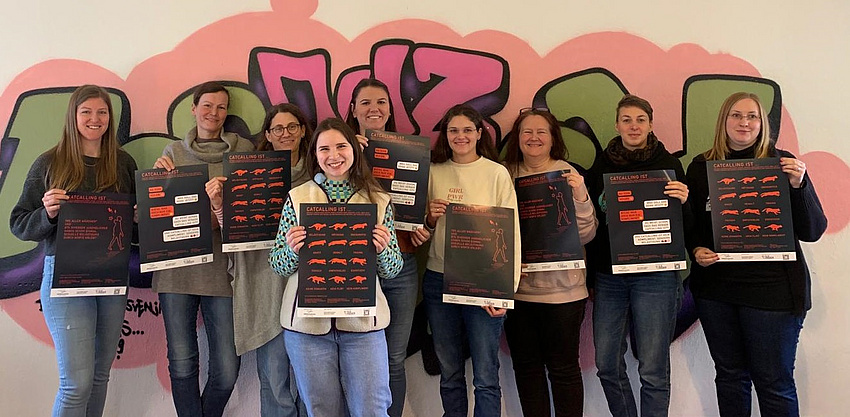 Eine Gruppe von Frauen hält Plakate in die Kamera.