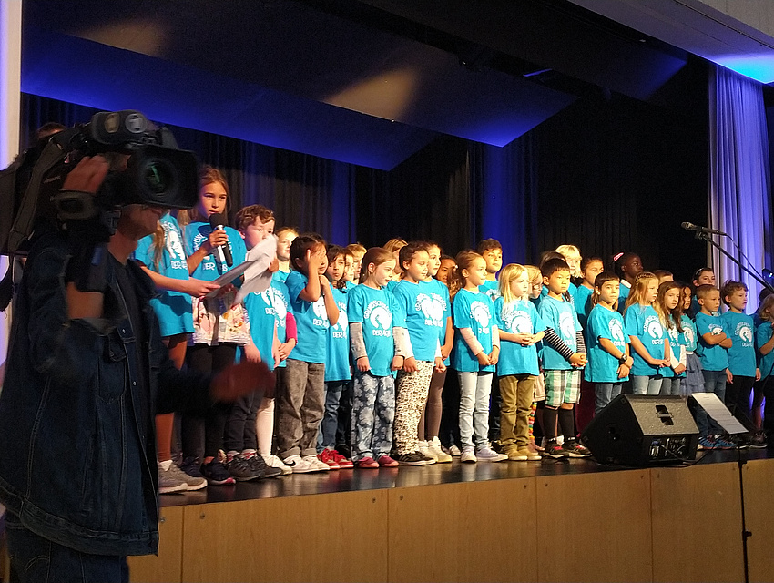 Bühne mit Kindern in hellblauen T-Shirts