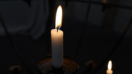 Eine leuchtende Kerze im Dunkeln.