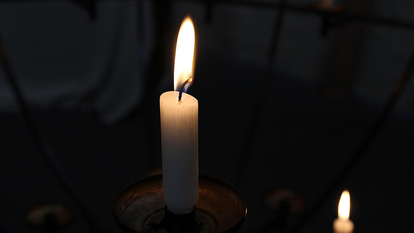 Eine leuchtende Kerze im Dunkeln.