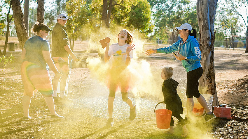 Eine Familie in der Natur, die sich mit Farbbeuteln bewirft