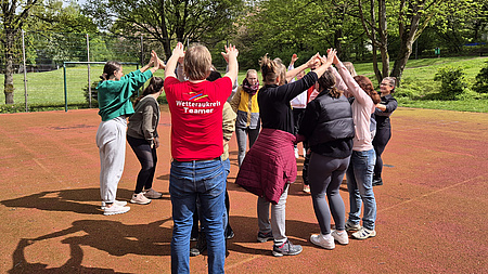 Eine Gruppe spielt ein Spiel auf einem Sportplatz.