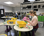 2 Mädchen bauen einen Roboter aus Lego Bausteinen