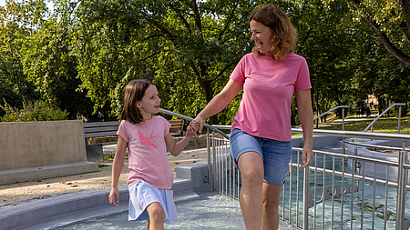 Eine Mutter und ihre Tochter beim Wassertreten in einem Kneipp-Becken.