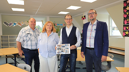 Vier Leute in einem Klassenraum.