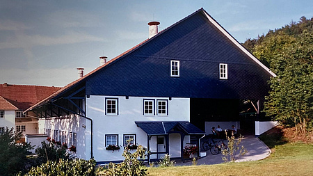 Ländlich gelegenes Haus mit vielen Fenstern und einem großen Dach