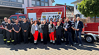 Eine große Gruppe Menschen steht vor einem Feuerwehrauto mit der Aufschrift Katastrophenschutz und dem Wappen des Wetteraukreises. .