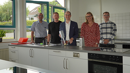 Fünf Personen in einer Küche.