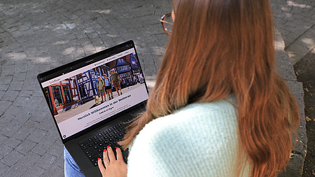 Eine junge Frau an einem Laptop.
