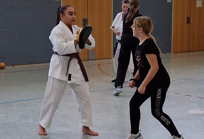 zwei Mädchen in der Sporthalle beim Karatetraining