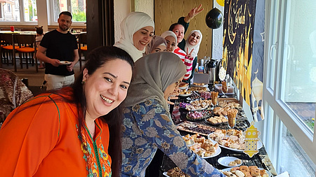 Mehrere Frauen stehen an einem langen Buffet.