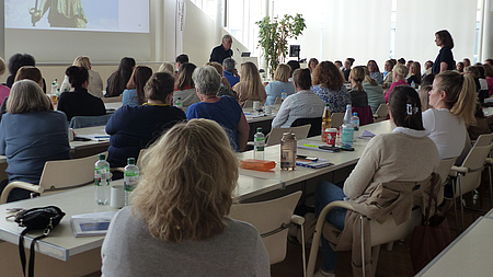 Personen im Saal hören einem Vortrag zu
