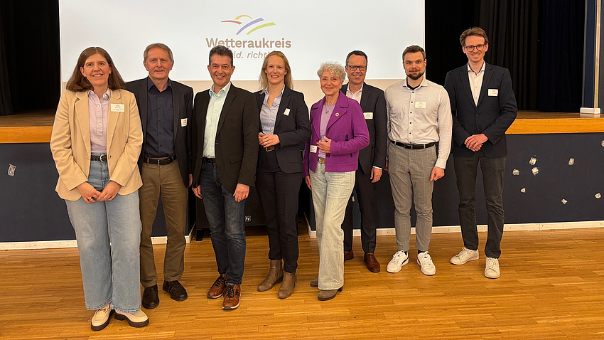 Eine Gruppe von Leuten lächelt in die Kamera.