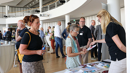 Menschen informieren sich an einem Infostand.