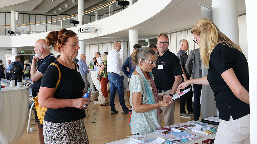 Menschen informieren sich an einem Infostand.