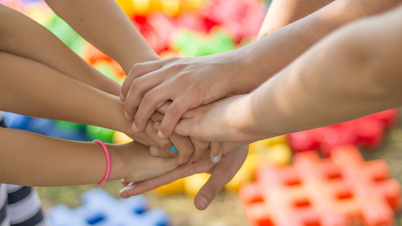 Symbolfoto: viele Personen legen ihre Hände zusammen