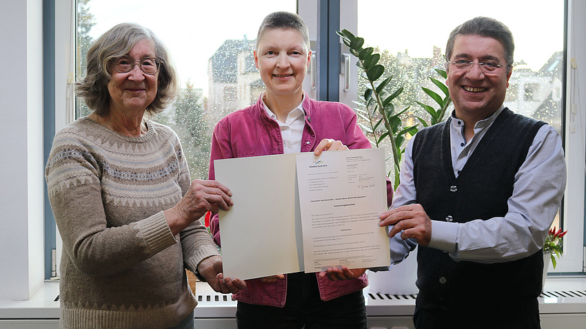 Marion Götz übergibt den Förderbescheid an Mehmet Turan und Beate Neuwirth.