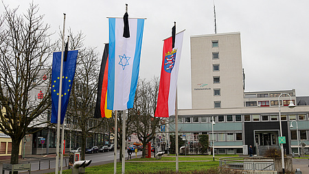 An den Fahnenstangen vor dem Kreishaus wehen die europäische, die deutsche, die hessische und die israelische Flagge, jeweils mit einem schwarzen Trauerflor.